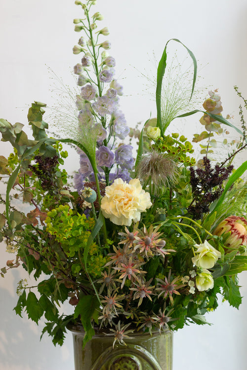 Floral arrangement in a green vase against a white background