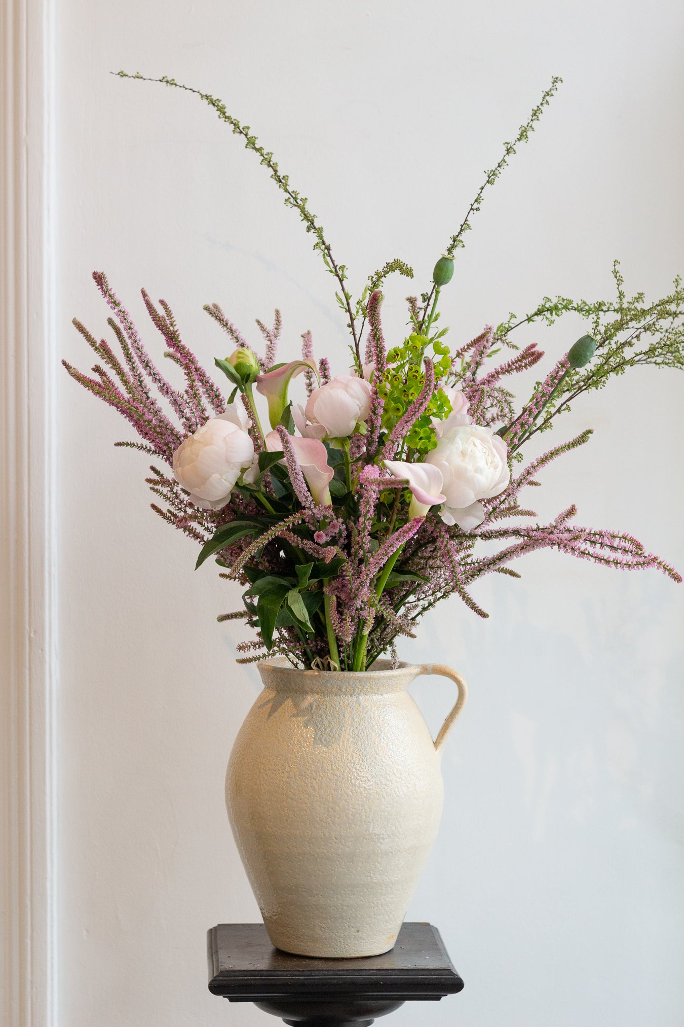 Floral arrangement in a white vase on a neutral background